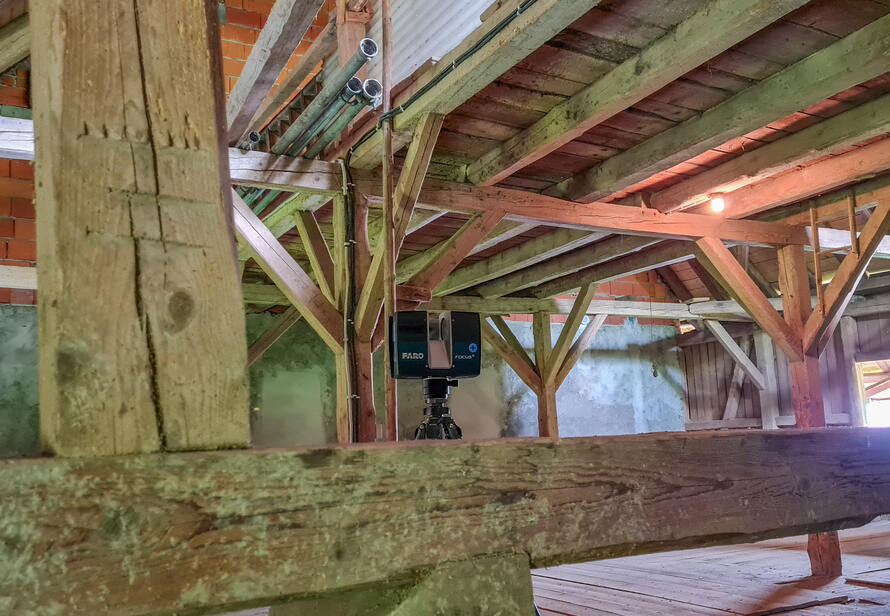 Laserscanner im Einsatz zur Vermessung eines historischen Dachstuhls, digitale Erfassung komplexer Holzkonstruktionen.