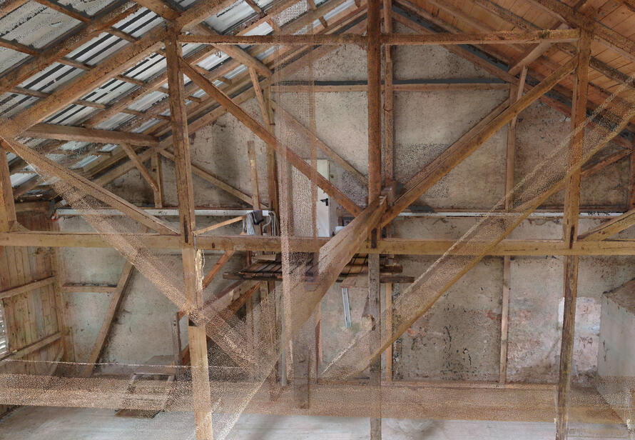 Punktwolke einer alten Scheune mit sichtbarer Dachkonstruktion und Tragwerk, präzise erfasst durch 3D-Laserscanning als Grundlage für ein verformungsgerechtes 3D-Modell.
