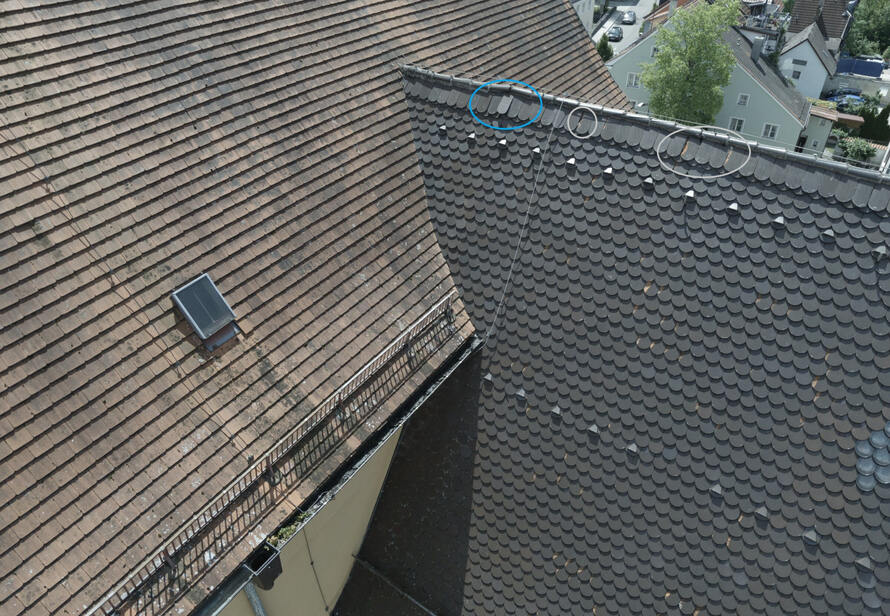 Drohneninspektion eines Ziegeldachs mit markierten Schadstellen. Frühzeitige Erkennung von losen oder beschädigten Dachziegeln zur Sicherstellung der Verkehrssicherheit.
