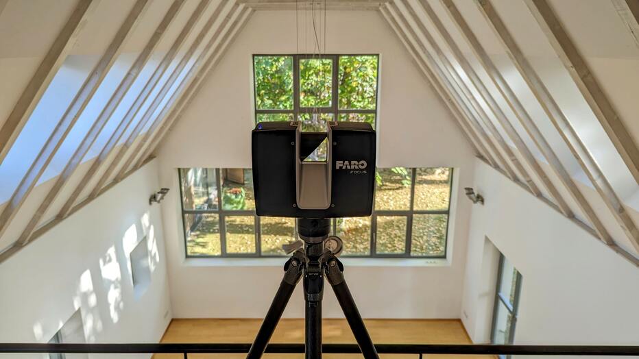 3D-Laserscanner bei der Architekturvermessung eines modernen Innenraums mit offenem Dachstuhl und hoher Raumgeometrie